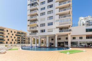 a large building with a swimming pool in front of it at Open Space in Armação de Pêra