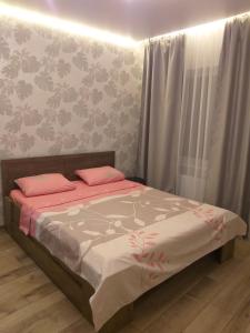Un dormitorio con una cama con almohadas rosas. en Апартаменты рядом с метро Защитников Украины, Спортивная en Járkov