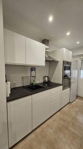 LAS OLAS BEACH 2 في توريفايجا: مطبخ بخزائن بيضاء ومغسلة