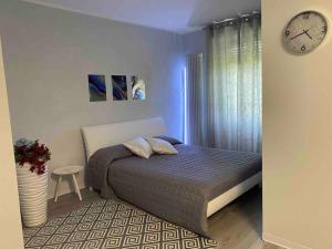 1 dormitorio con 1 cama y reloj en la pared en Casavacanzalacorte, en Cadrezzate