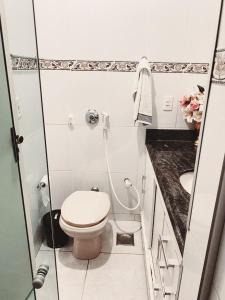 a white bathroom with a toilet and a sink at APTO - Espaço Village Completo - 2Q in Vitória