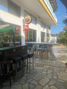 a bar with tables and stools outside of a restaurant at Blue Bay Beach Hotel in Koinyra