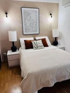 Charmant Appartement centre-ville في أجاكسيو: غرفة نوم بسرير كبير فيها مصباحين