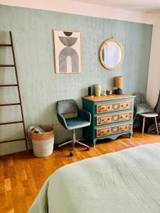 a bedroom with a dresser and a chair and a mirror at Charmant Appartement centre-ville in Ajaccio