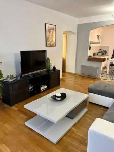 sala de estar con TV y mesa de centro blanca en Charmant Appartement centre-ville en Ajaccio