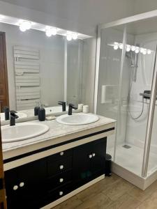 a bathroom with two sinks and a shower at Charmant Appartement centre-ville in Ajaccio