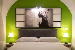 1 dormitorio con una pared verde, 1 cama y 2 lámparas en Terra dell'Etna, en Catania