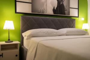 1 dormitorio con cama blanca y pared verde en Terra dell'Etna, en Catania