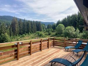 a deck with chairs and a view of the woods at Le Perchoir - Gîte 7 personnes / pleine nature / Altitude : 830 m in Ban-sur-Meurthe-Clefcy