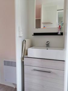 a bathroom with a white sink and a mirror at Mobil Home Le Rimbaud - 4/6 pers - 2 ch - 2 sdb in Saint-Jean-de-Monts