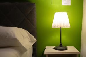 una lámpara en una mesita de noche junto a una cama en Terra dell'Etna, en Catania
