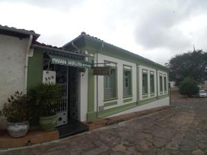 un pequeño edificio verde y blanco con una puerta en Pousada Gameleira, en Diamantina