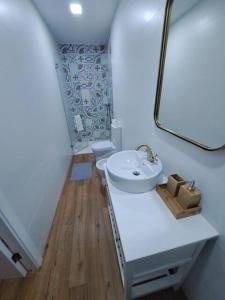 Baño blanco con lavabo y espejo en Beach House en Espinho