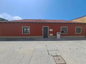 ein rotes Gebäude mit einer Tür auf einem Parkplatz in der Unterkunft Beach House in Espinho