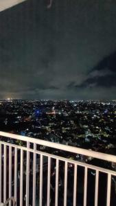 een balkon met uitzicht op de stad 's nachts bij The Pod by M&C in Manilla