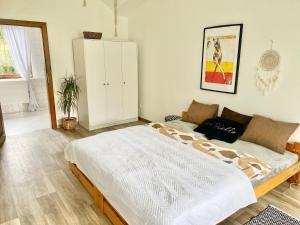 ein Schlafzimmer mit einem großen Bett und einem weißen Schrank in der Unterkunft Apartmán v koňském areálu Židovice in Louny