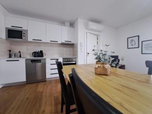 een keuken met een houten tafel en een keuken met witte kasten bij Beach House 2 in Espinho