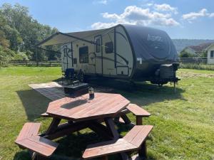 una mesa de picnic con un remolque en un campo en Penn State Weekender en State College