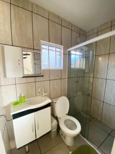a bathroom with a toilet and a sink and a shower at Sobrados Molhes in Passo de Torres +27 photos