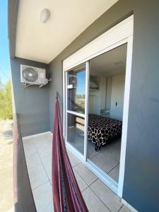 a room with a balcony with a bed and a window at Sobrados Molhes in Passo de Torres