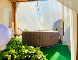 a hot tub sitting in a room with plants at Apartmani "Mimoza" in Otočac