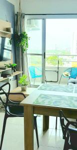 een tafel en stoelen in een kamer met een groot raam bij Cómodo apartamento cerca al mar. in Cartagena
