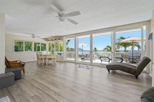 a living room with a ceiling fan and a view of the ocean at @ Marbella Lane - Sunshine Seascape Ocean View in Kaneohe