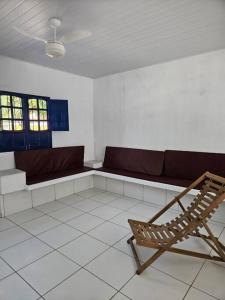 Habitación con sofá y silla. en Aconchegante casa perto da praia da Enseada dos Golfinhos OBS não é Jaguaribe en Jaguaribe