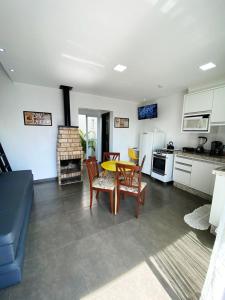 a kitchen and dining room with a table and chairs at Sobrados Molhes in Passo de Torres