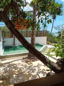palma pochylająca się nad basenem w obiekcie DuMangue Kite House w mieście Guriú
