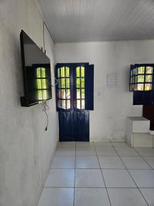 een kamer met een deur en een tegelvloer bij Aconchegante casa perto da praia da Enseada dos Golfinhos OBS não é Jaguaribe in Jaguaribe