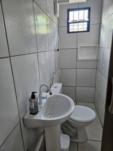 een badkamer met een wastafel en een toilet bij Aconchegante casa perto da praia da Enseada dos Golfinhos OBS não é Jaguaribe in Jaguaribe