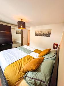 um quarto com uma cama grande e almofadas amarelas em Au Grand Pierrot em Spa