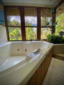 a large white bath tub in a bathroom with windows at Suite con jacuzzi y bellas vistas in Lanalhue Lake