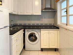 eine Küche mit Waschmaschine und Spüle in der Unterkunft Apartamento cerca de la playa in Maspalomas