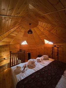 een slaapkamer met een bed in een houten kamer bij Hotel Nordmann,Racha in Ambrolauri