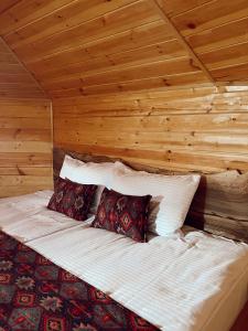 Cama en habitación con techo de madera en Hotel Nordmann,Racha, en Ambrolauri