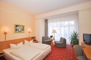 een hotelkamer met een bed en een televisie bij Hotel Binzer Hof in Binz