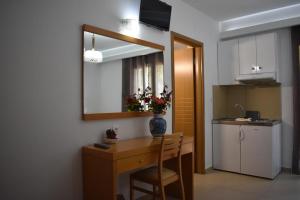 eine Küche mit einem Schreibtisch und einer Blumenvase darauf in der Unterkunft Hotel Ritsa in Kamena Vourla