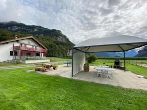 a pavilion with a picnic table and a building at ”Heimet” im Berner Oberland in Unterbach
