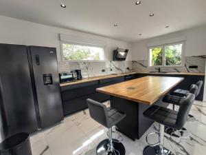 a kitchen with a wooden table and two bar stools at Villa à 900m des plages in Locquirec