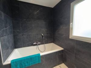 a shower in a bathroom with a green towel at Villa à 900m des plages in Locquirec +6 photos