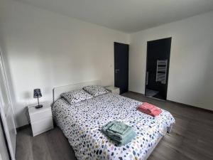 a bedroom with a bed with two bags on it at Villa à 900m des plages in Locquirec