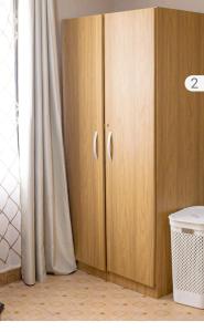 um armário de madeira num quarto com uma cortina em MED COZY FLAT GH em Acra