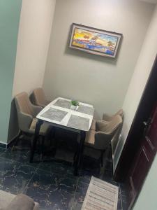 uma mesa numa sala com cadeiras e um jornal em MED COZY FLAT GH em Acra