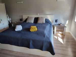 a bed with a blue blanket and two towels on it at Ferienwohnung Diekblick - Kleiner Deichhof in Hattstedtermarsch