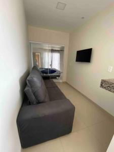 a living room with a couch and a television at Flat Delior 07 in Palmas