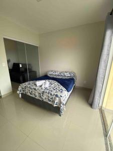 a bedroom with a bed with a blue comforter at Flat Delior 07 - Parada do Jalapão, rodoviária, faculdades e Aeroporto in Palmas