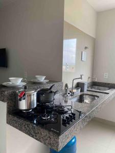 a kitchen counter with a stove and a sink at Flat Delior 07 in Palmas