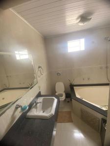 łazienka z umywalką, wanną i toaletą w obiekcie Quarto em Foz do Iguaçu w Foz do Iguaçu